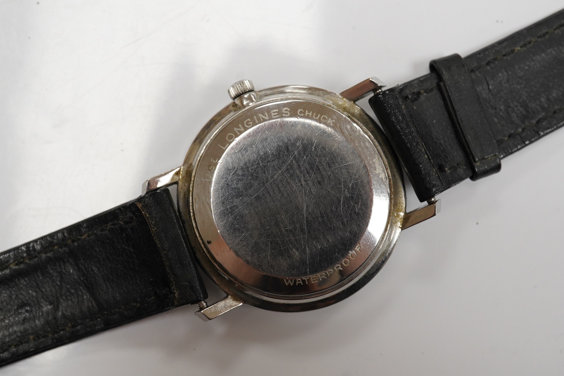 A gentleman's stainless steel Longines automatic wrist watch, with baton numerals and date aperture, case diameter 35mm, on an associated leather strap. Condition - poor